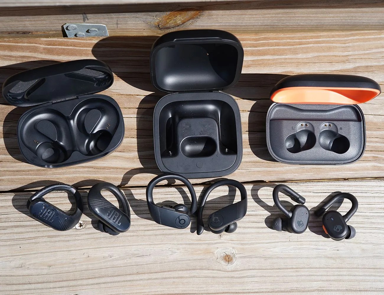 wireless earbuds with ear hooks laying on wood panels