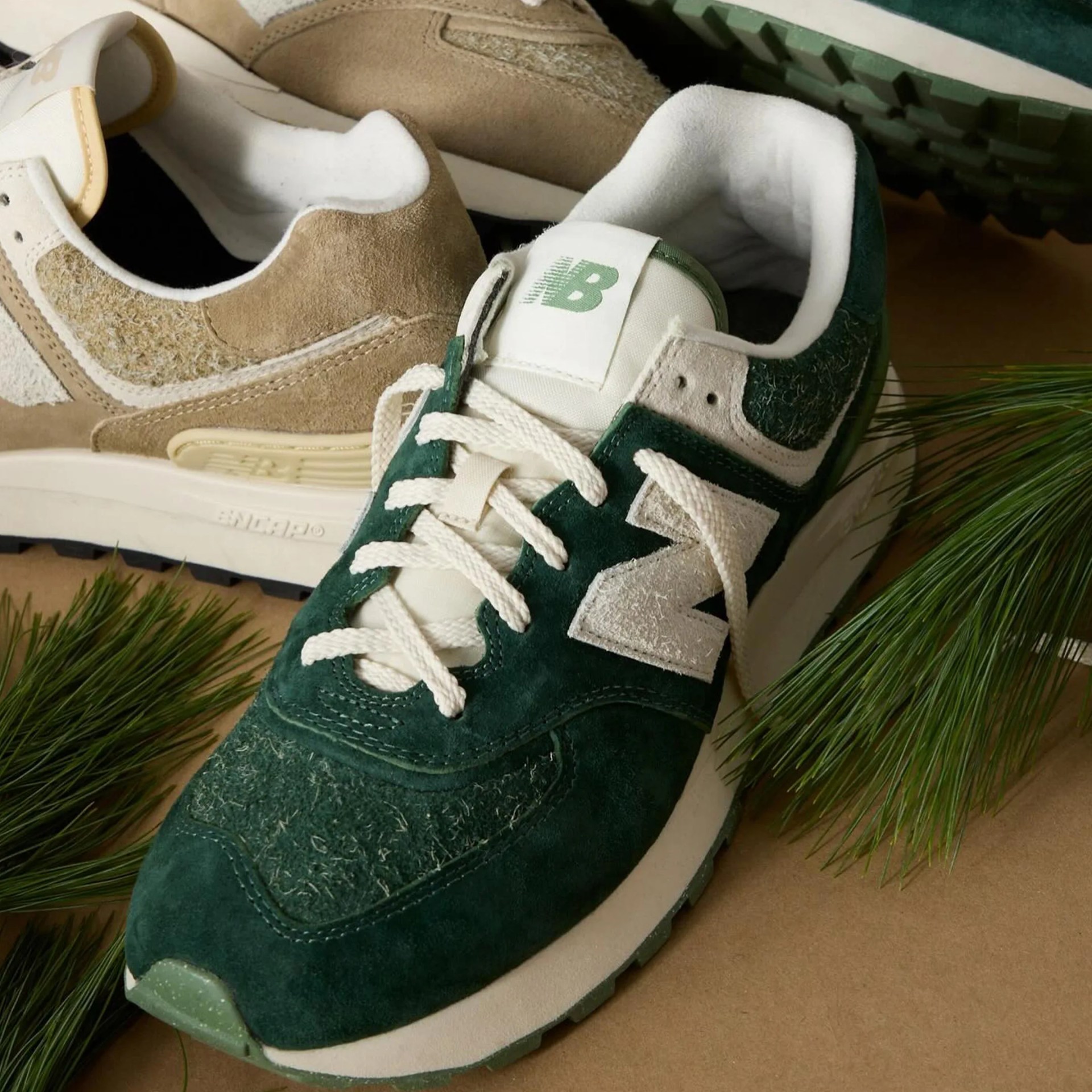 todd snyder x new balance sneakers next to some pine needles