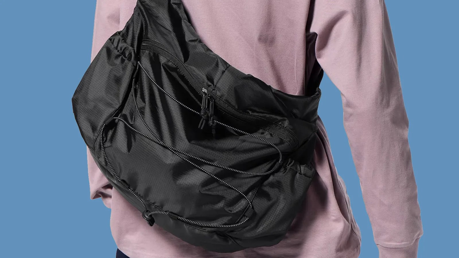 GU Ripstop Messenger Bag being worn on the back of a personal wearing a pink long sleeve