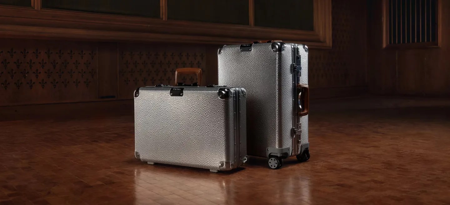 rimowa aluminum luggage on a wood floor