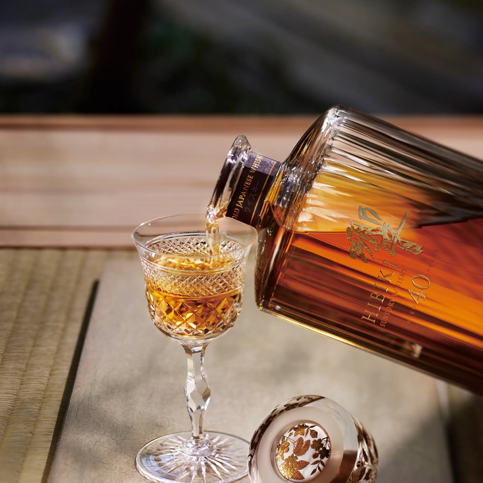 a bottle of hibiki japanese whisky is poured into a glass