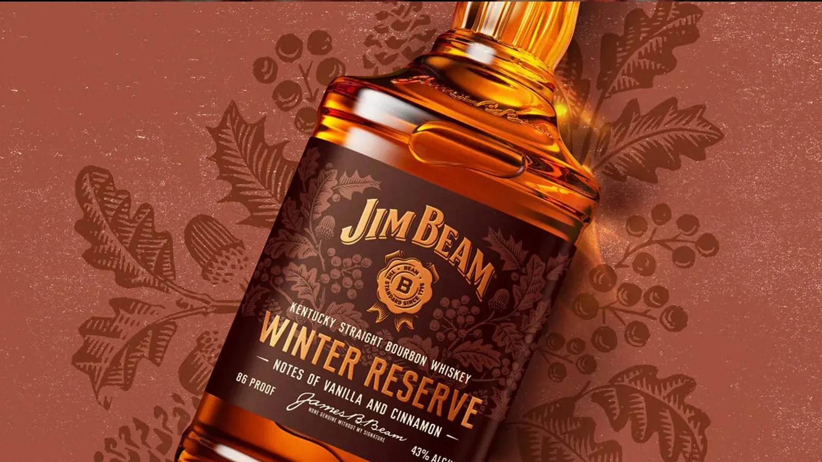 A close up of a bottle of Jim Beam Winter Reserve Bourbon shown at an angle highlighting the dark maroon brownish label. It's sitting on a dark read background with a holly leaf pattern.