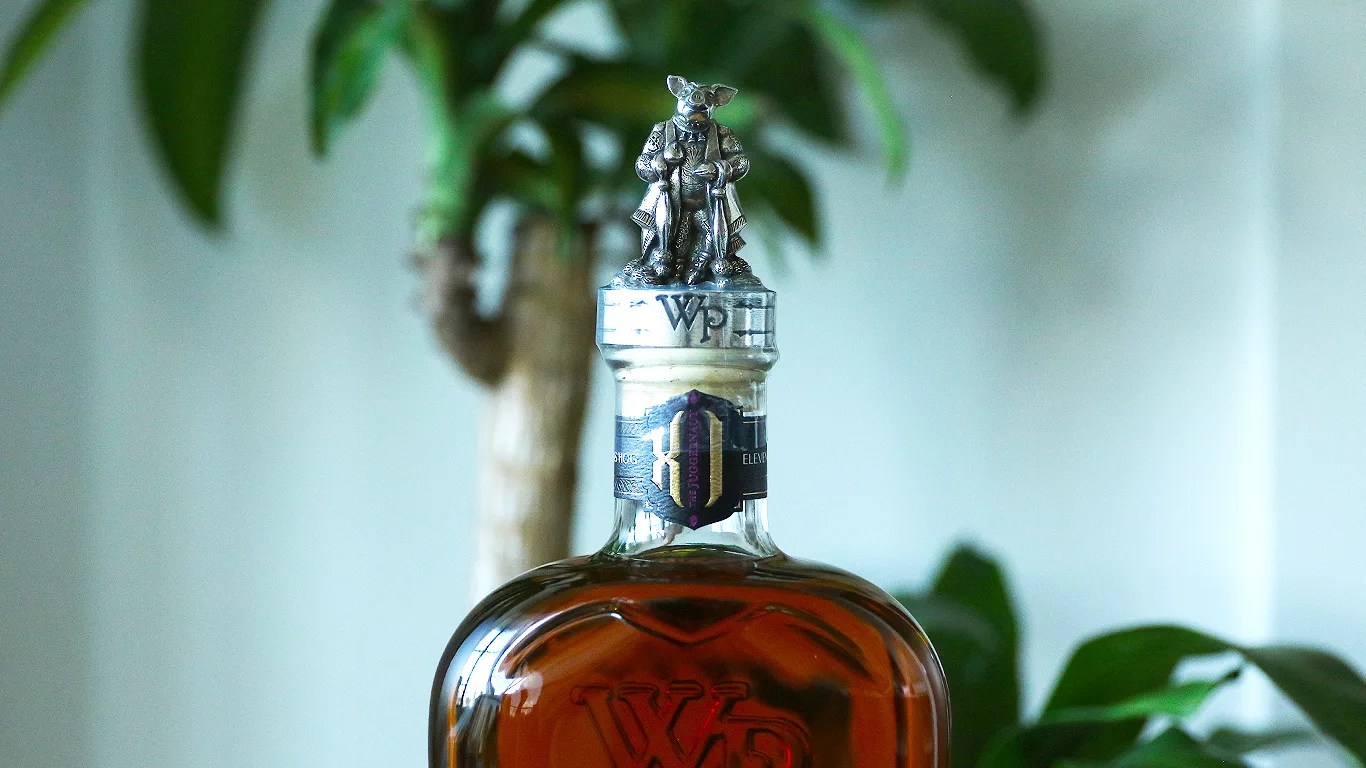 closeup of a whistlepig whiskey bottle in front of a house plant