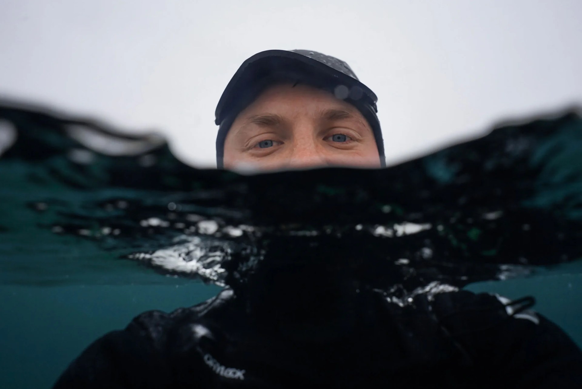 a self portrait of a man in a hooded wetsuit in the water