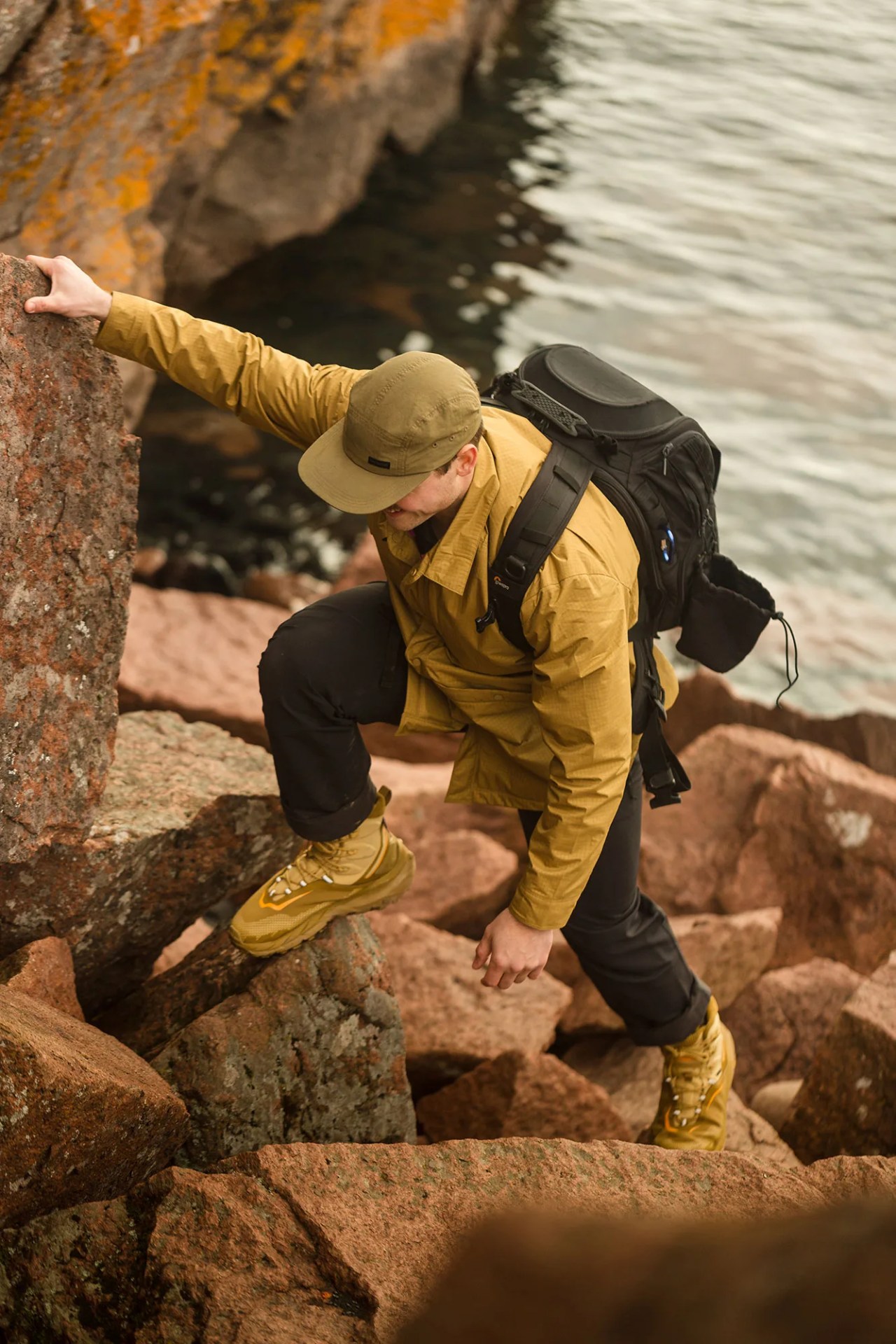 a man hikes up a boulder field